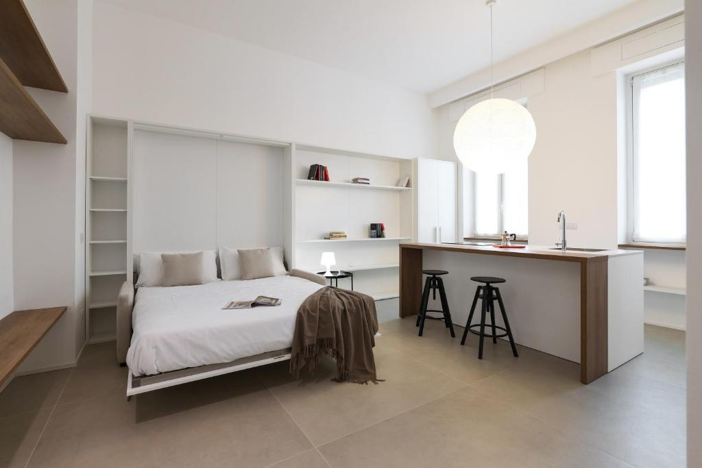 ein weißes Schlafzimmer mit einem Bett und einem Schreibtisch in der Unterkunft Contempora Apartments - Cermenate 54B in Mailand