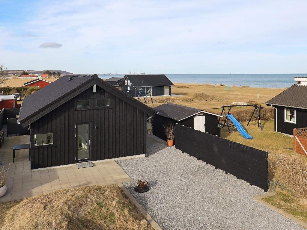 uma vista aérea de uma casa preta com um parque infantil em 5 person holiday home in Frederikshavn em Frederikshavn