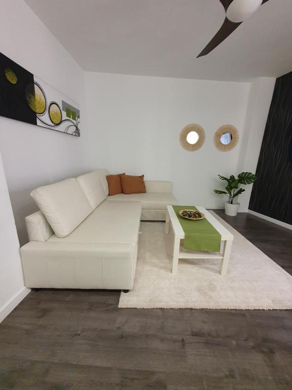 sala de estar con sofá blanco y mesa en Tribuna Deluxe, en Málaga