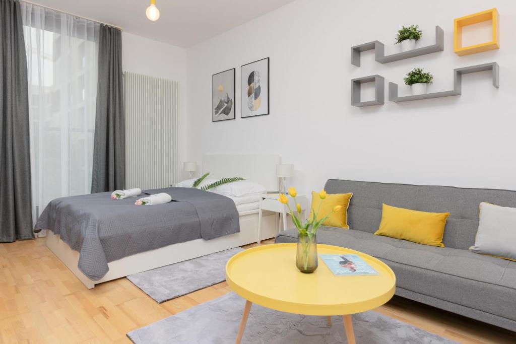 a living room with a couch and a table at Warsaw Wola Apartment near Nocny Market by Noclegi Renters in Warsaw