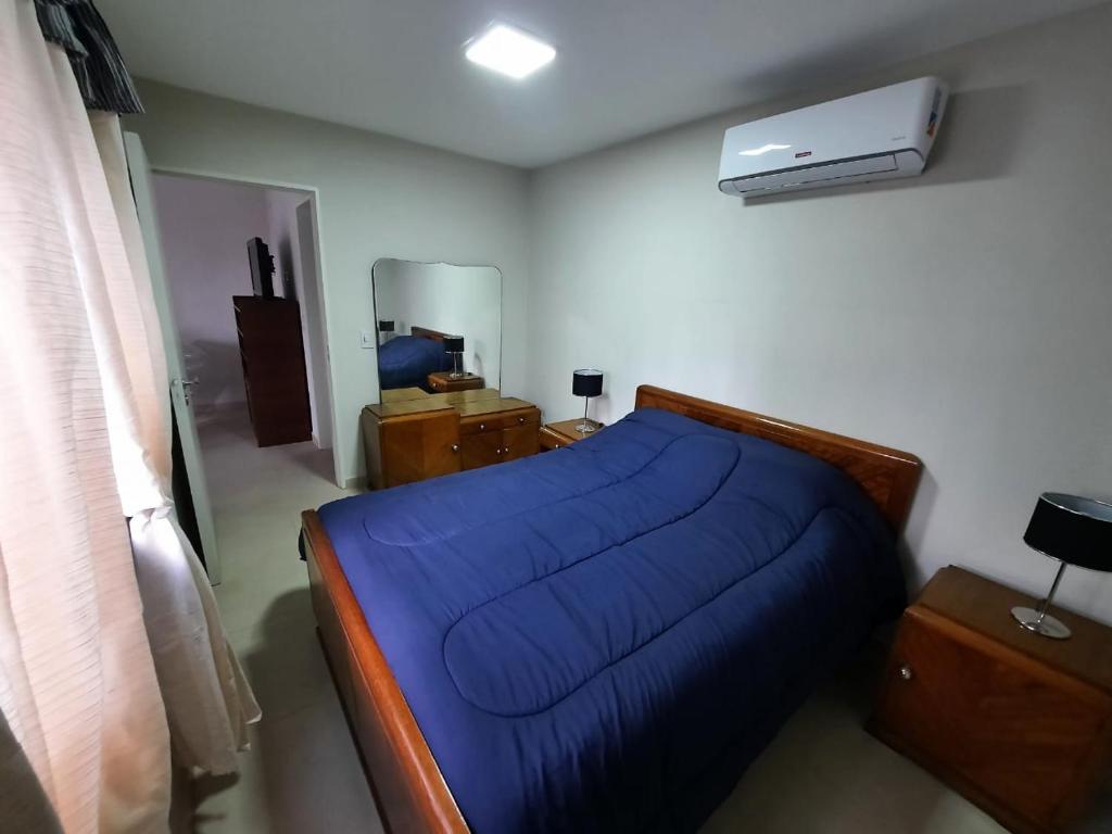 アルタ・グラシアにあるCOMPLEJO CRUZのベッドルーム(青いベッド1台、エアコン付)