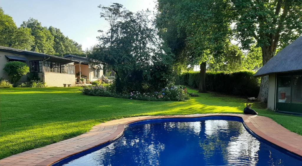 a swimming pool in the yard of a house at Rosedale Self Catering Cottage with pool and large entertainment BBQ area in Henburg Park
