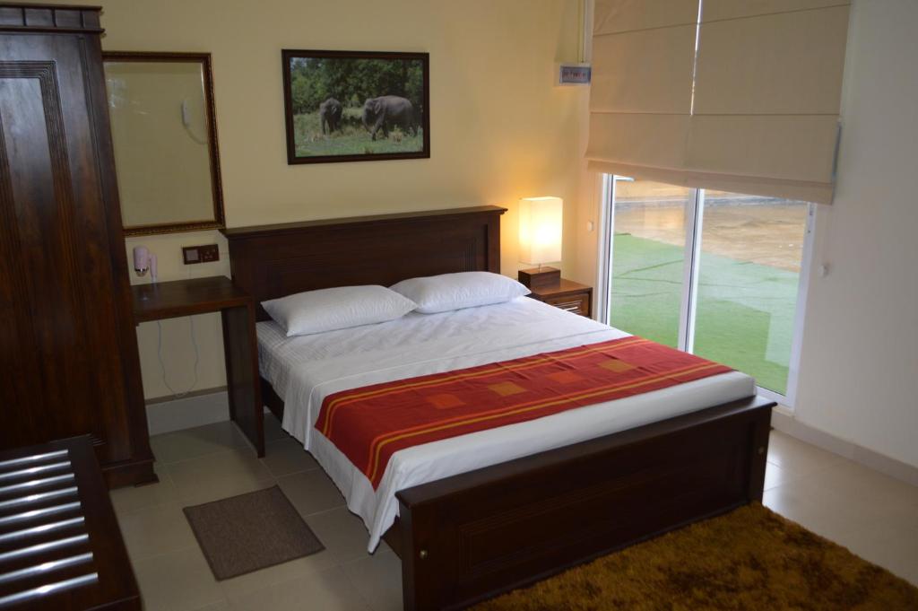 um quarto com uma cama e uma grande janela em Paramount Residence 5 em Peliyagoda
