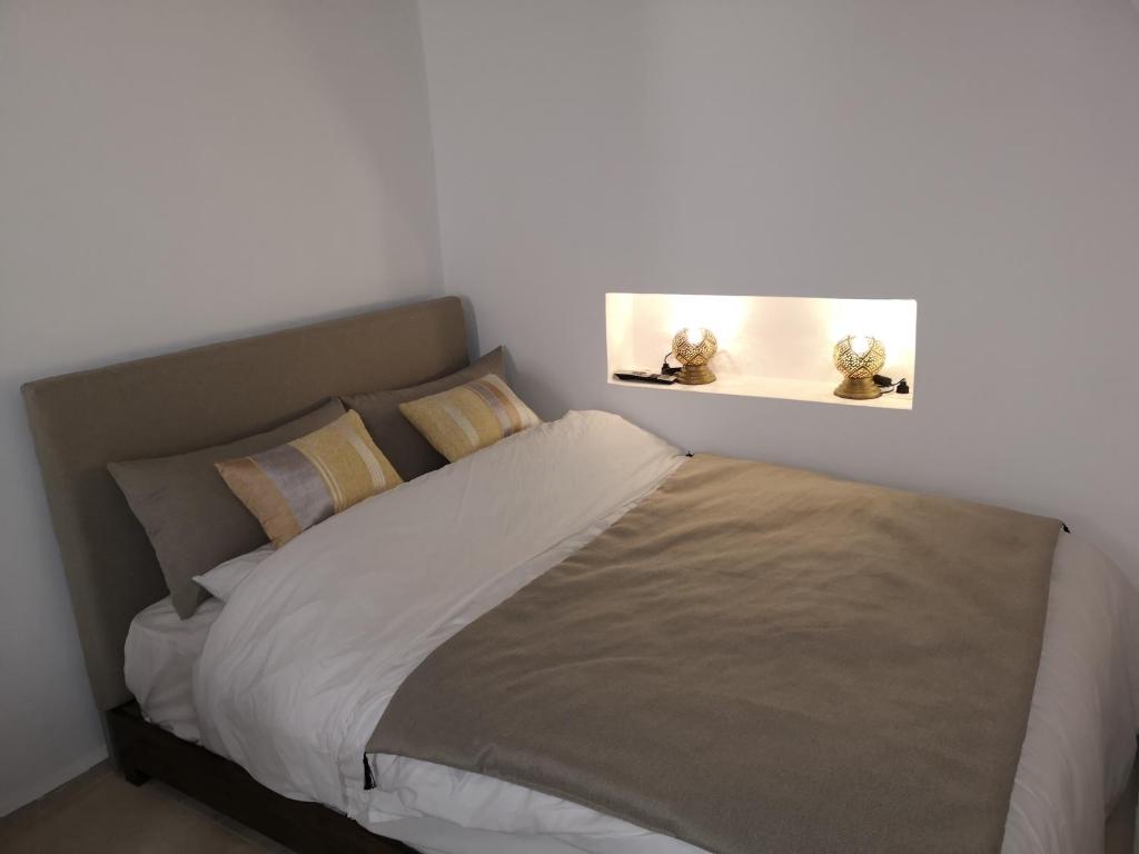 Un dormitorio con una cama con dos lámparas encima. en Riad de charme l'Oasis d'Essaouira - Chambre Luxe, en Essaouira