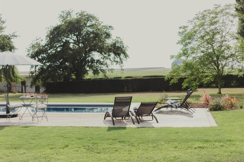 a group of chairs and a table next to a pool at Domaine de Jouarre in Jouarre