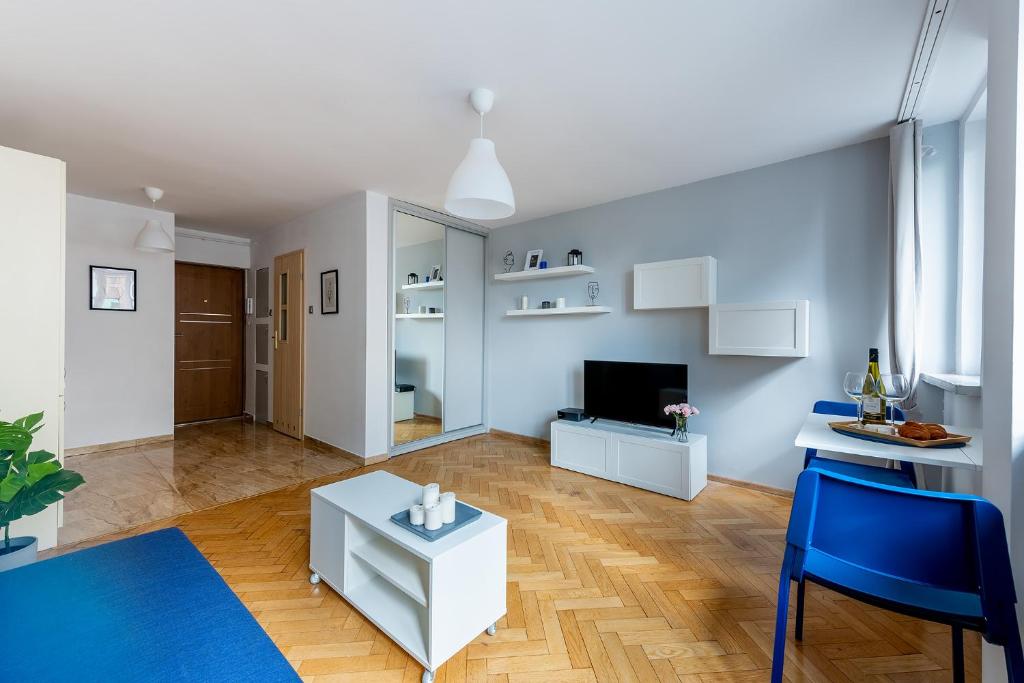 ein Wohnzimmer mit einem Tisch und blauen Stühlen in der Unterkunft Śliska 10 Prywatne mieszkanie 300m od Dworca Centralnego oraz metra ONZ in Warschau