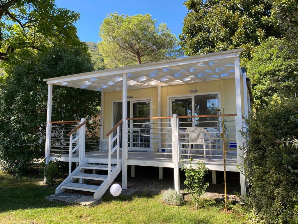una pequeña casa con porche y escaleras en el césped en Villaggio Turistico Riviera, en Cannobio