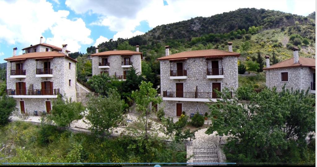 um grupo de edifícios do lado de uma montanha em Koustenis Village em Dimitsana