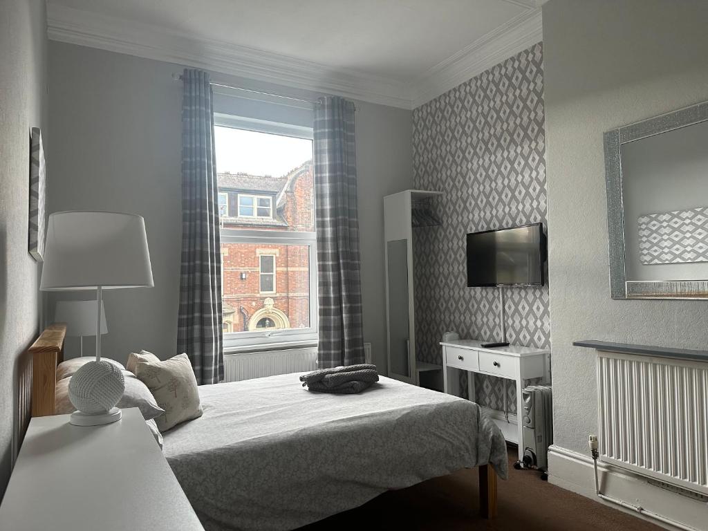 ヨークにあるFriars Rest Guest Houseのベッドと窓が備わるホテルルーム