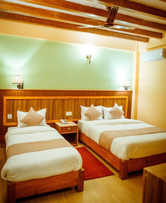 una camera d'albergo con due letti di Paradise Boutique Hotel a Pokhara