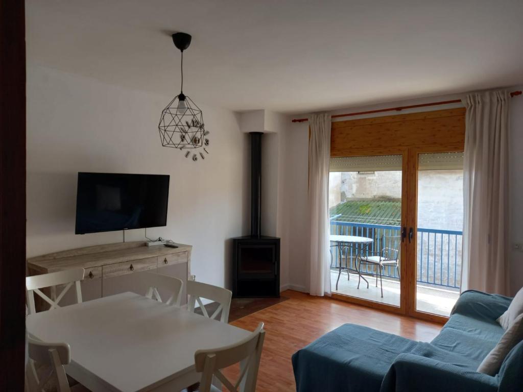 a living room with a couch and a table and a television at Pis Acollidor amb LLar de Foc, al Centre Camprodon in Camprodon