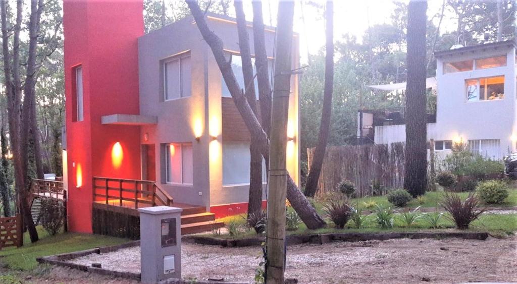 una casa roja y blanca en el bosque en EL PINAR CASA DE PLAYA en Balneario Mar Azul