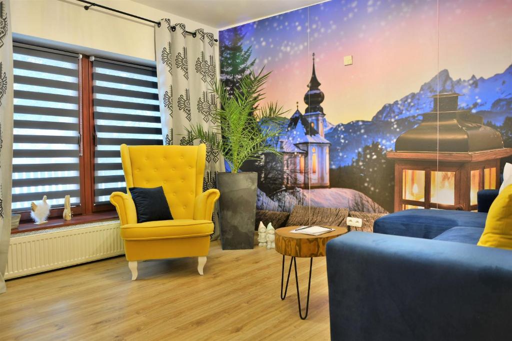 salon z niebieską kanapą i żółtym krzesłem w obiekcie Czarna Willa w Zakopanem