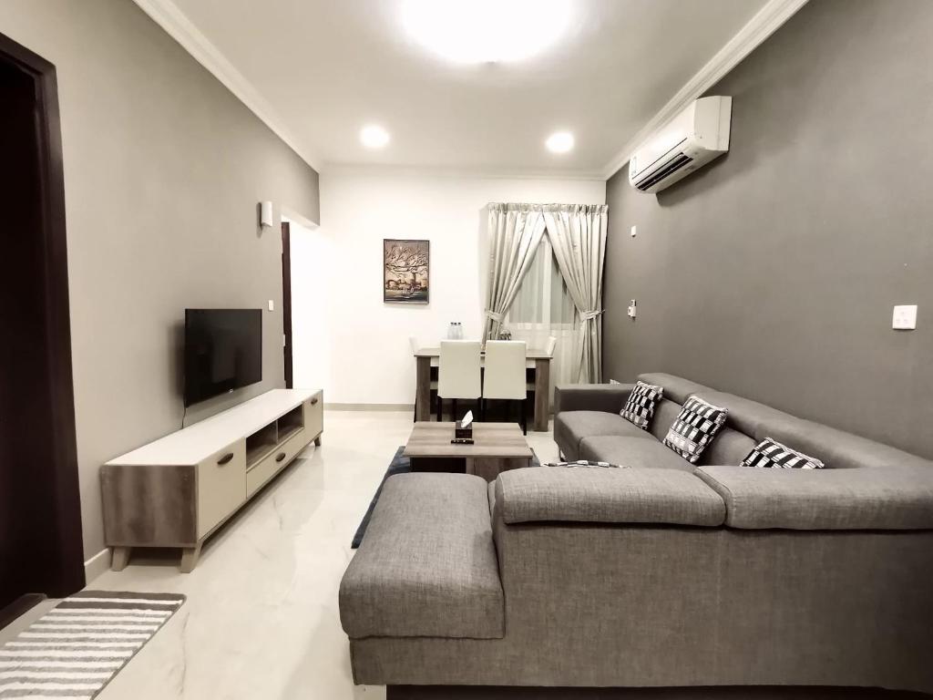 a living room with a couch and a flat screen tv at Al Muftah Homes in Doha