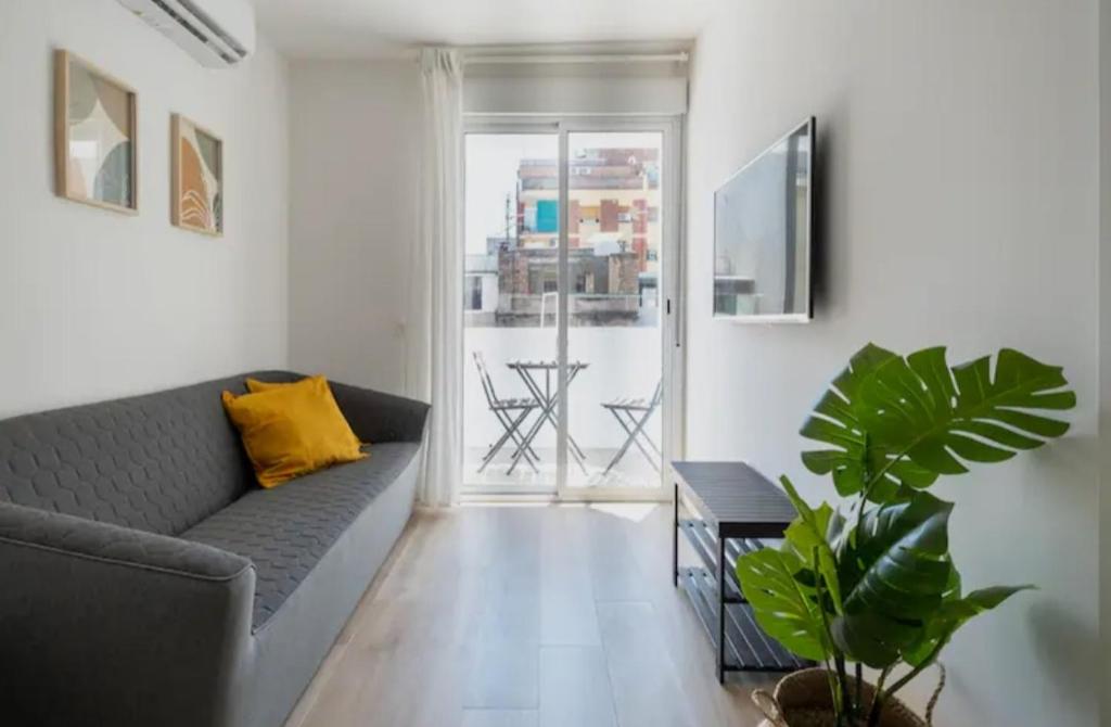 a living room with a couch and a table at Apartment close to the beach in Sant Adria de Besos
