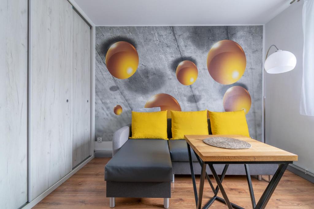 sala de estar con sofá y almohadas amarillas en Apartament Morcinka en Bytom