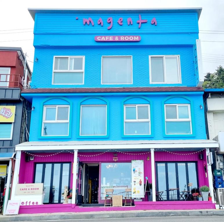 een blauw gebouw met een bord erop bij Magenta in Donghae