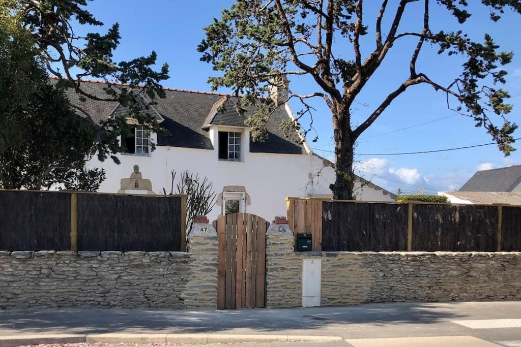 une maison blanche avec une clôture et un portail en bois dans l'établissement Villa Salicorne, à Quiberon