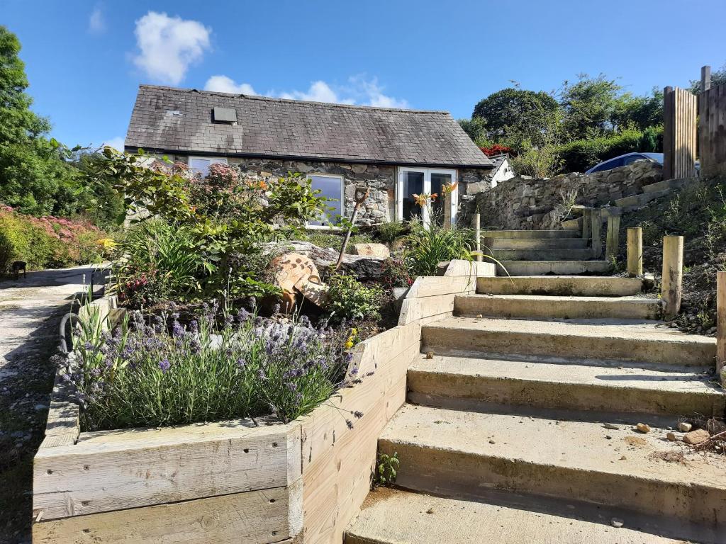 un conjunto de escaleras delante de una casa con flores en Ty Carreg Bach, en Llanrwst