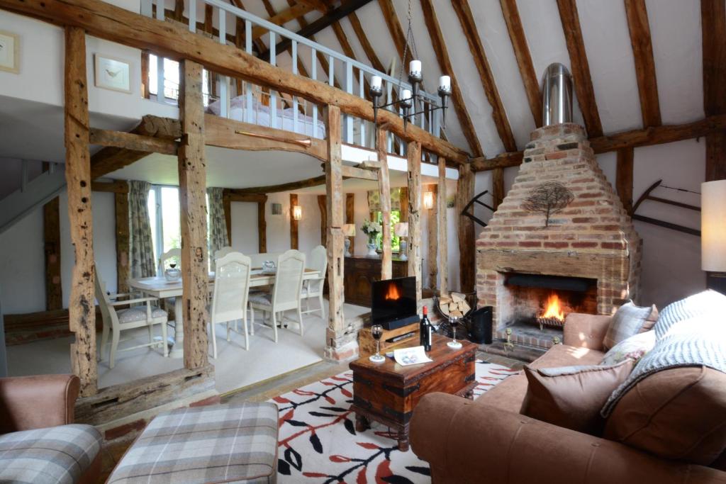 - un salon avec une cheminée en pierre dans une maison dans l'établissement Wassicks Cottage, Haughley, à Haughley