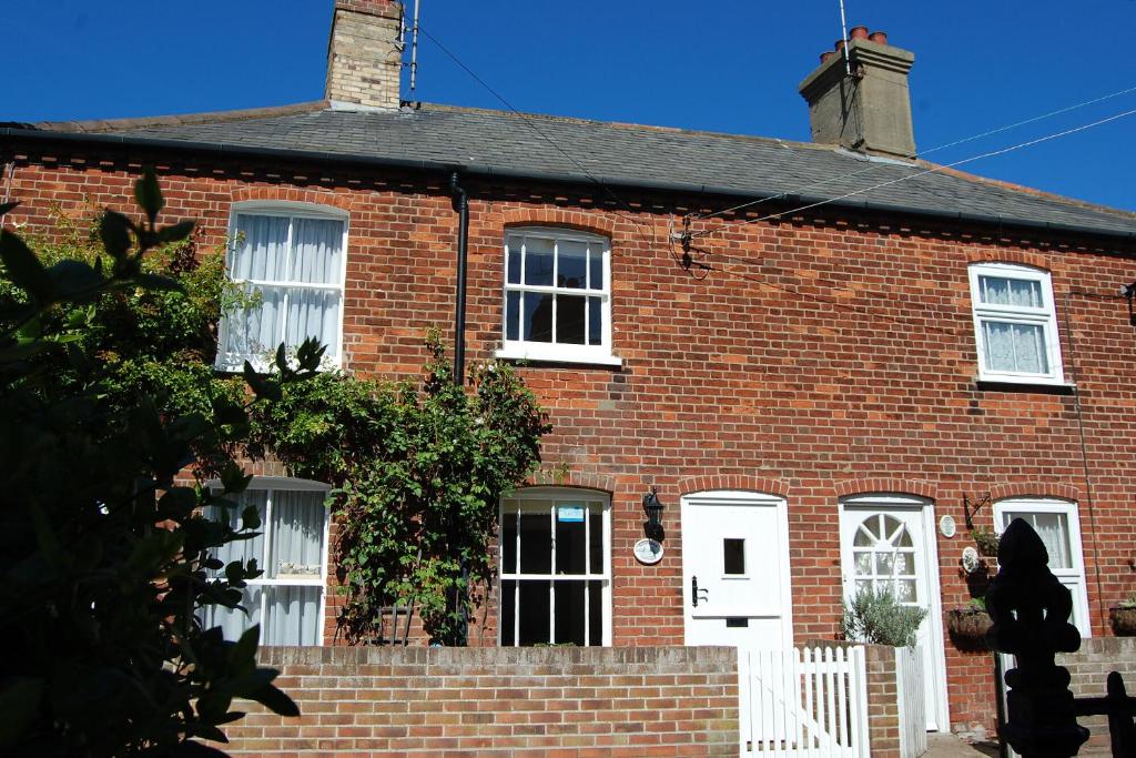 dom z czerwonej cegły z białymi drzwiami i oknami w obiekcie Shrimpers Cottage, Aldeburgh w mieście Aldeburgh
