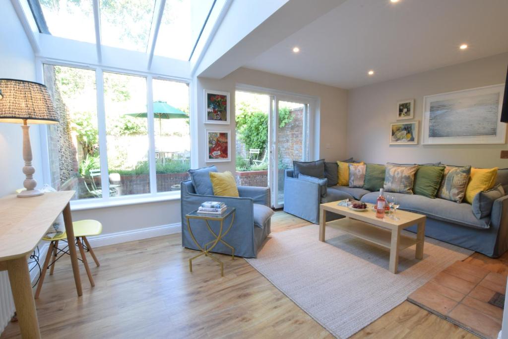 ein Wohnzimmer mit Sofa und Tisch in der Unterkunft Seawall Cottage, Aldeburgh in Aldeburgh