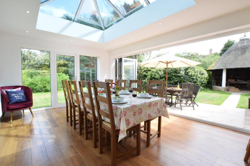 a conservatory with a table and chairs and a glass ceiling at Rippleway, Walberswick in Walberswick