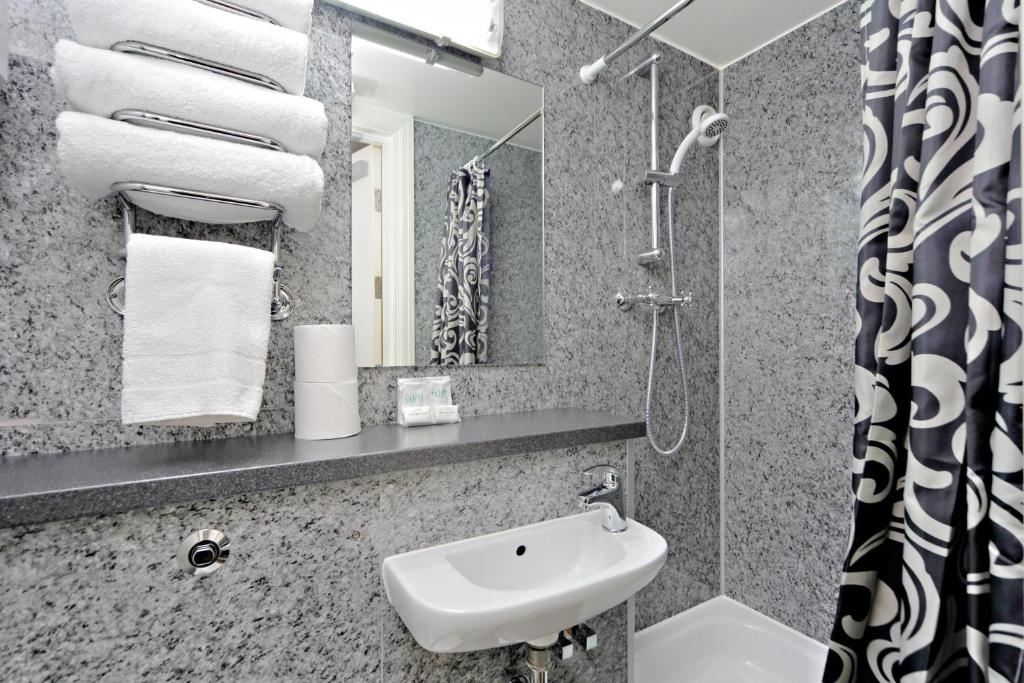 a bathroom with a sink and a mirror at London Visitors Hotel in London