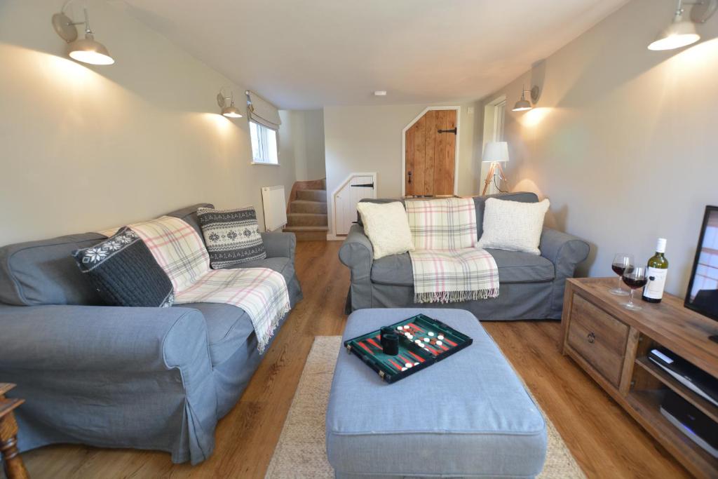 a living room with two couches and a table at Little Turnpike Cottage, Melton in Woodbridge