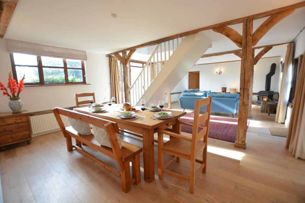a dining room with a wooden table and chairs at Wheelwright's Barn in Halesworth
