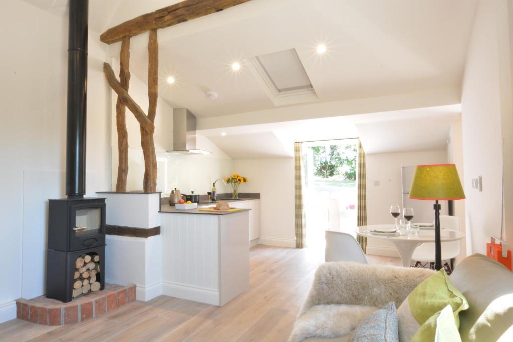 eine Küche und ein Wohnzimmer mit einem Herd in der Unterkunft Carriage House, Bruisyard in Framlingham