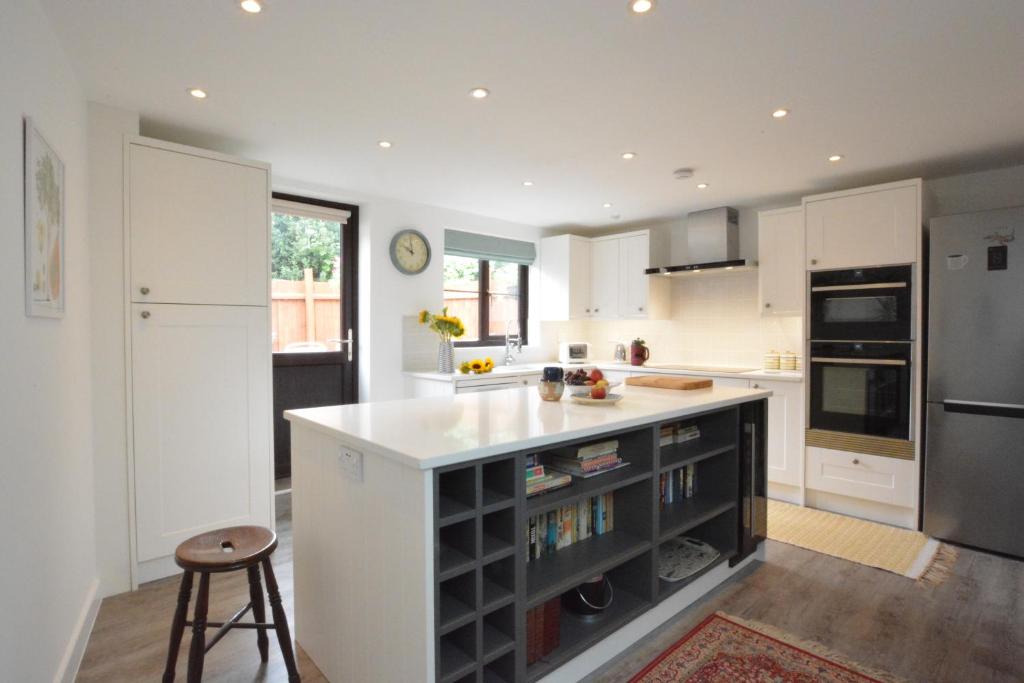 eine Küche mit weißen Schränken und einer weißen Arbeitsplatte in der Unterkunft Pine Cottage in Woodbridge