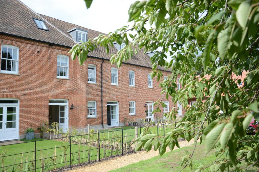 an old red brick building with white windows at Ploughman's Green, Blythview in Blythburgh