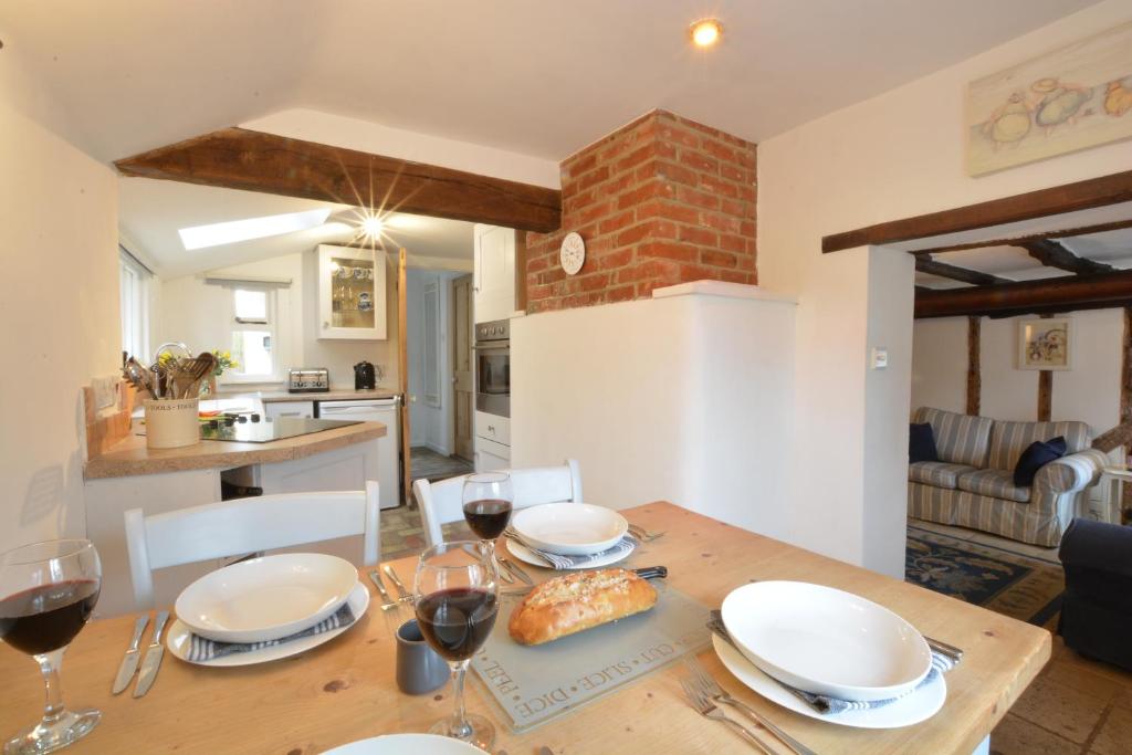 a dining room table with glasses of red wine at The Moorings, Orford in Orford