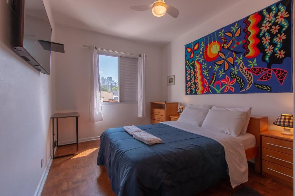 a bedroom with a bed and a painting on the wall at Casa no Tatuapé com Garagem e Portão Automático in Sao Paulo