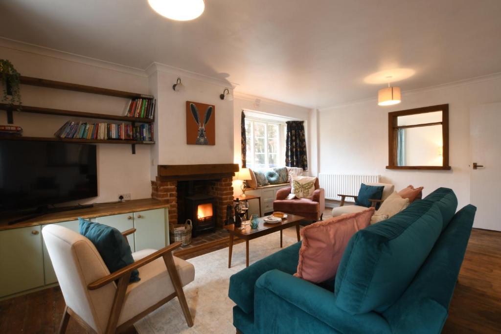 a living room with a blue couch and a fireplace at Rosedene, Rickinghall in Rickinghall
