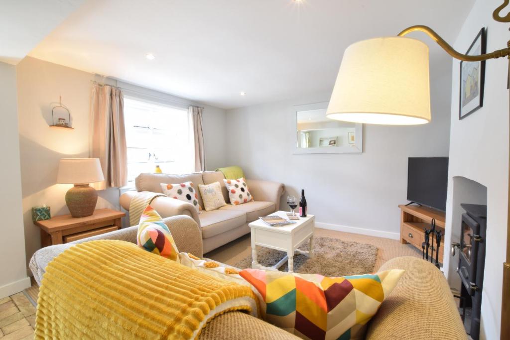 a living room with a couch and a tv at Satis Cottage, Westleton in Westleton