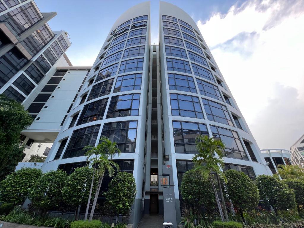 un grand bâtiment avec des palmiers devant lui dans l'établissement River Place, à Singapour