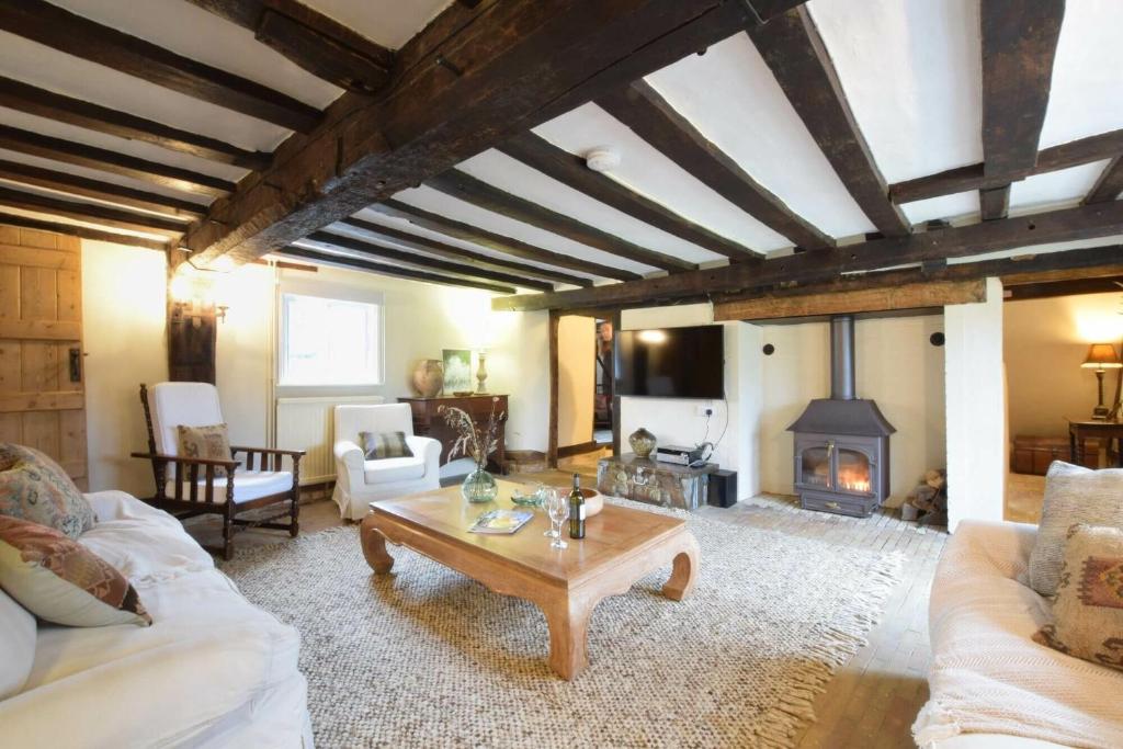 a living room with a table and a fireplace at Church Farmhouse, Cookley in Halesworth