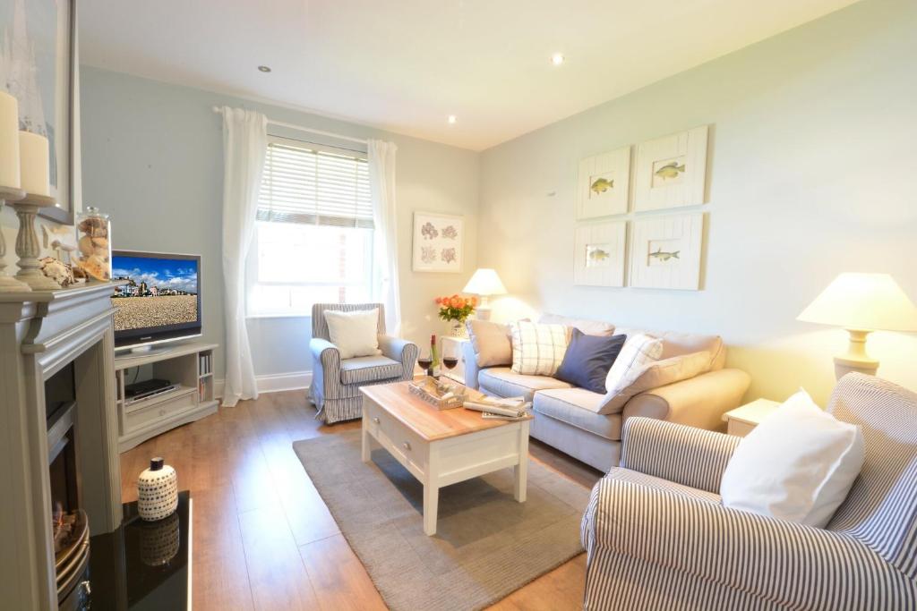ein Wohnzimmer mit 2 Sofas und einem TV in der Unterkunft High Tide, Crabbe Street, Aldeburgh in Aldeburgh