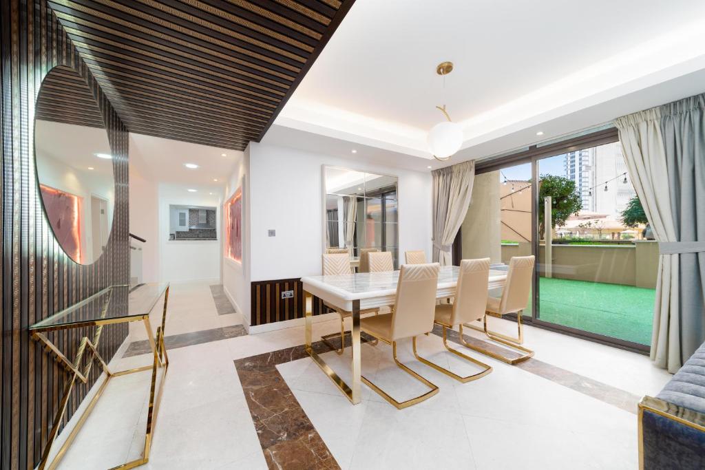 een eetkamer met een tafel en stoelen bij Elan Suites 5-Bedroom Beach Villa in Dubai