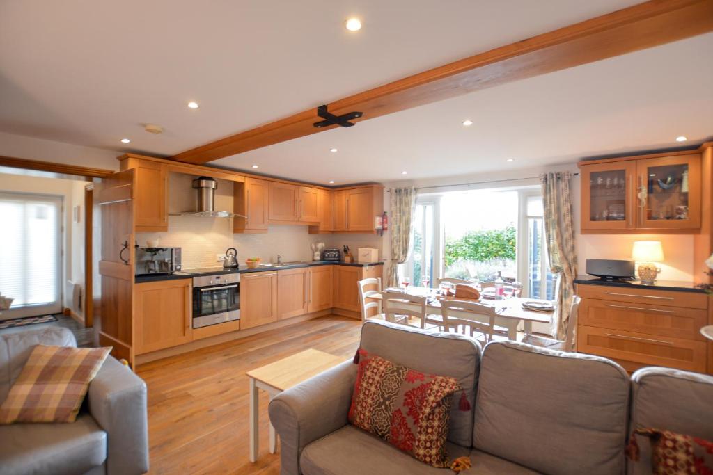 a living room with a couch and a kitchen at Three Chantry Barns, Orford in Orford