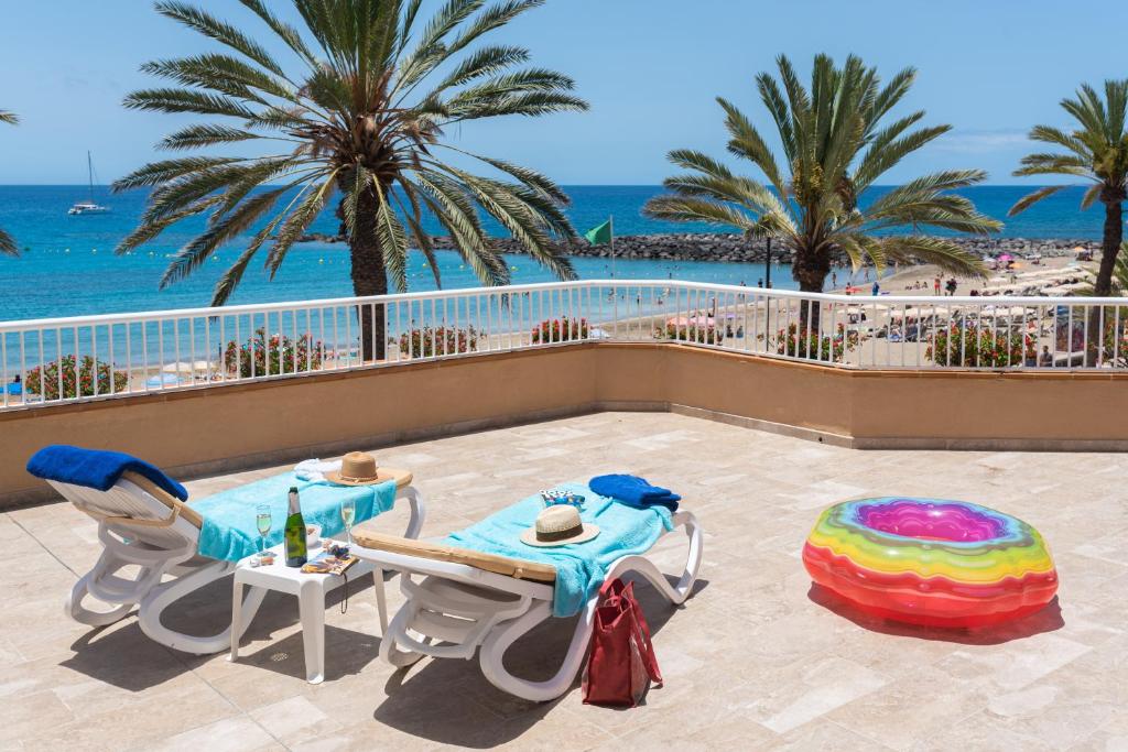 a patio with a table and chairs and the ocean at Apartamentos Vista Sur in Playa de las Americas