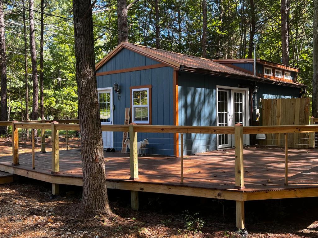 una casita azul en una terraza en el bosque en Knotty Pines Cabin near Kentucky Lake, TN, en Springville