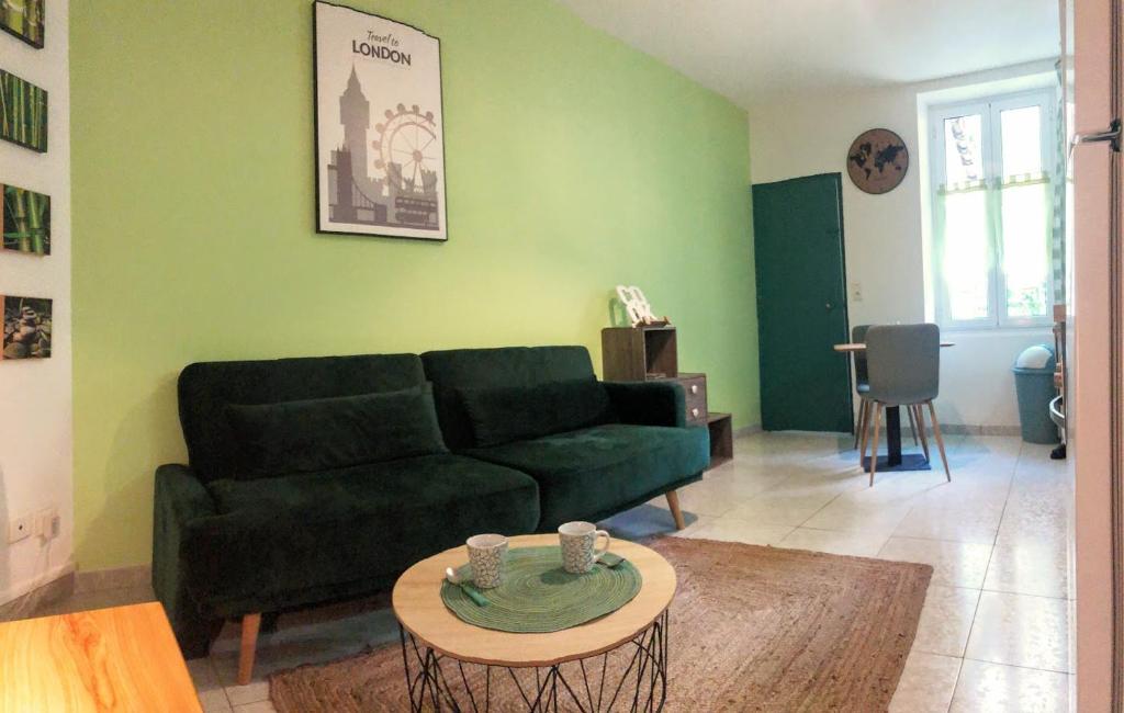 a living room with a green couch and a table at T2 entièrement équipé et refait à neuf à 10mn Alès in La GrandʼCombe