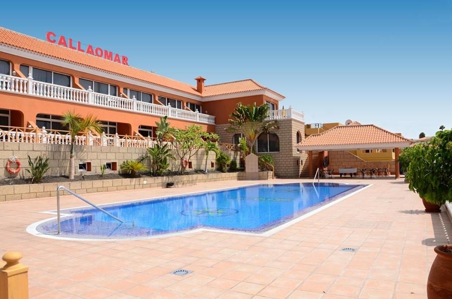 a swimming pool in front of a hotel at Apartamentos Callaomar in Callao Salvaje