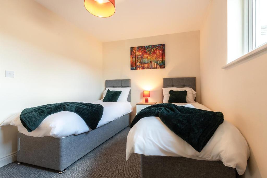 two beds in a bedroom with a painting on the wall at BEST PRICE! STUNNING 2 Bed City Centre - 4 single beds or 2 Super king, Smart TVs, Sofa Bed & FREE SECURE PARKING in Southampton