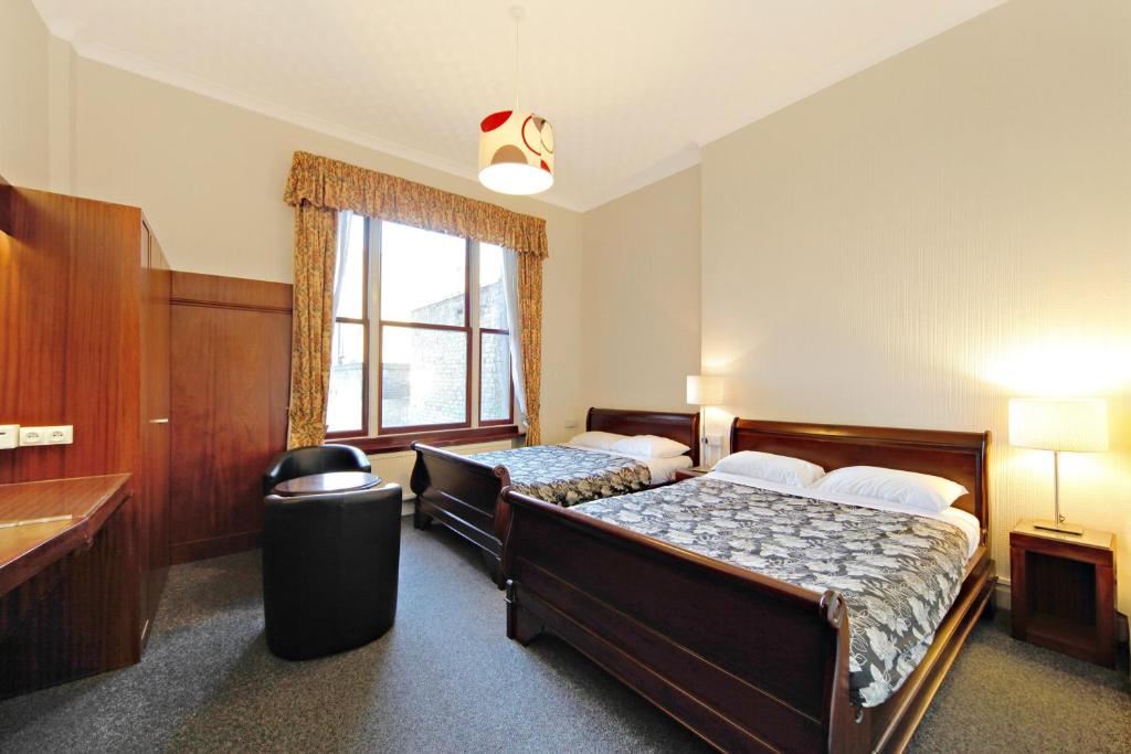 a bedroom with two beds and a window at London Visitors Hotel in London