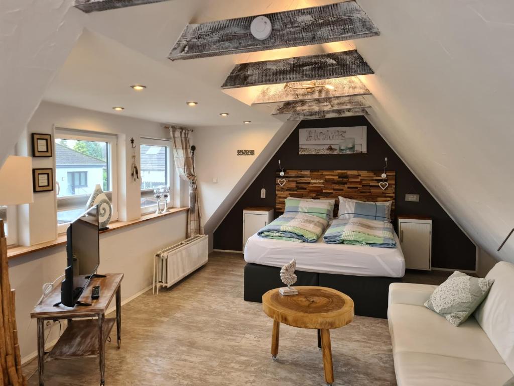 a loft bedroom with a bed and a couch at Stylisches Garden Cottage in Weyhe