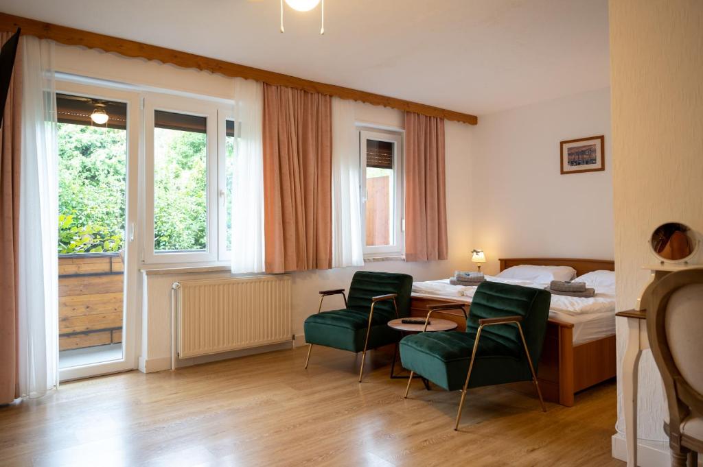 a room with a bed and a table and chairs at Pension Kitty in Pörtschach am Wörthersee
